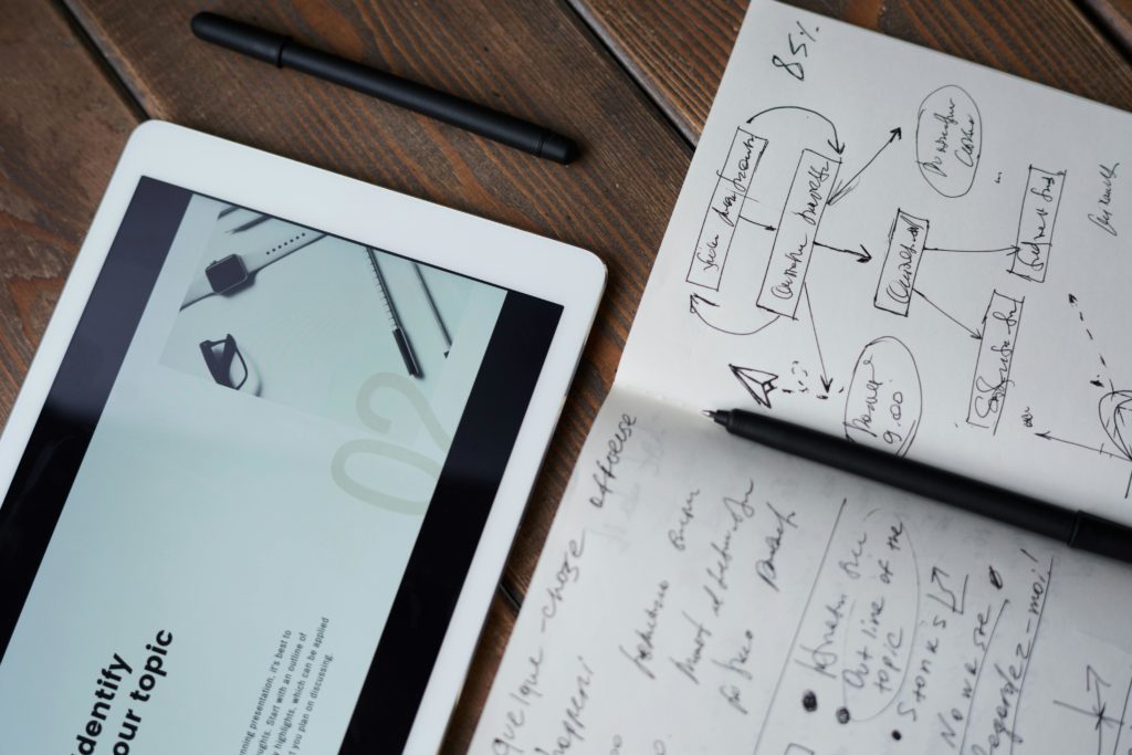 Handwritten notes near tablet with system on